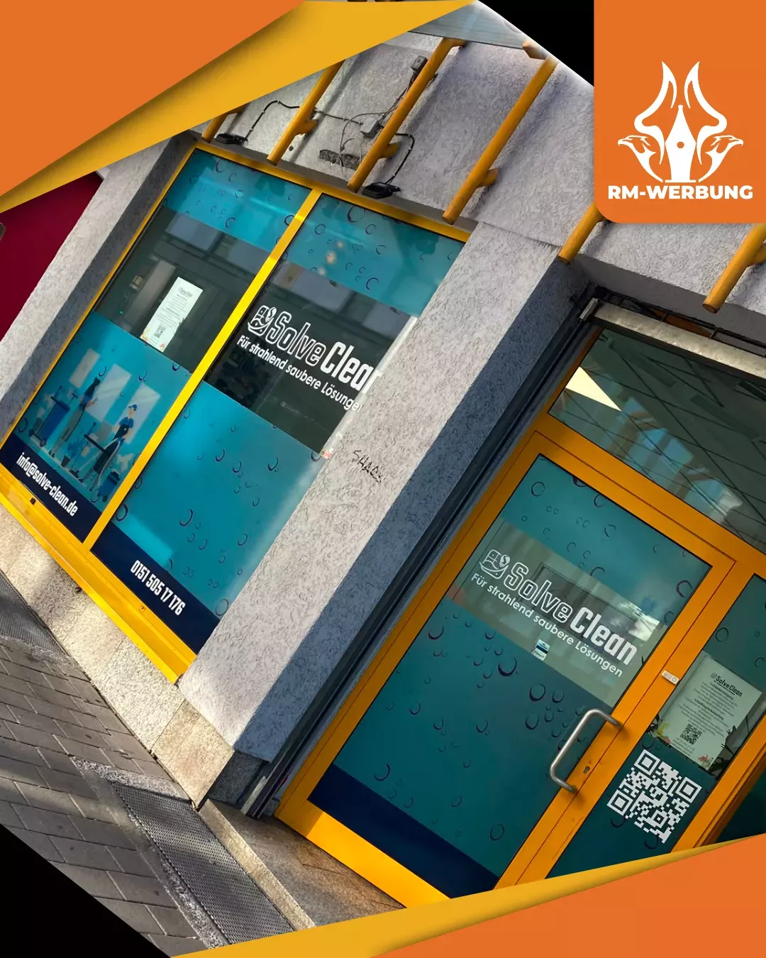 Schaufensterfolierung für SolveClean in Kaiserslautern Schräge Außenansicht der gelb gerahmten Fenster und Eingangstür, foliert mit bedruckter, hellblauer Milchglasfolie im Seifenblasen-Design