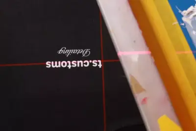 Siebdruck des ts.customs-Logos auf schwarzem T-Shirt mit Laser-Positionierung