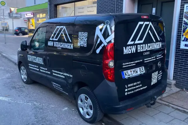 Schwarzer Servicewagen der M&W Bedachungen GmbH mit weißer Fahrzeugbeschriftung, Logo und QR-Code